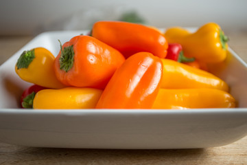 Bell peppers in a rectangular dish on a weathered wood backgroun