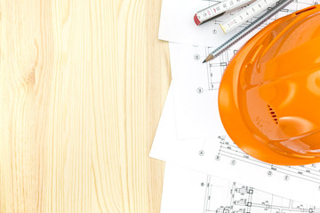 safety helmet with architectural plans and wooden ruler