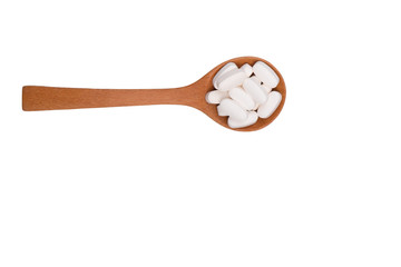 Tablet pill on wood spoon isolated on white background