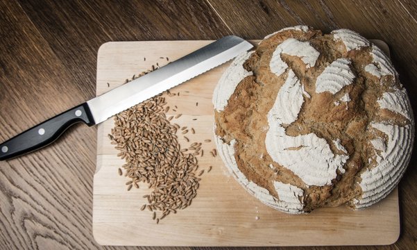 selbst gebackenes Brot mit Messer und Getreide