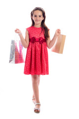 shopping concept - cute little girl with bags isolated on white background
