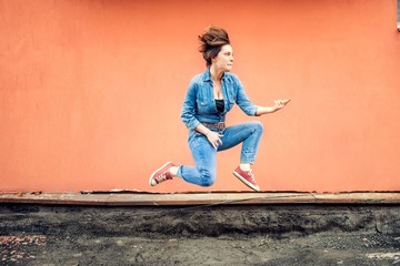Portrait of happy girl jumping and singing in a hot summer day. Modern concept of stylish girl...