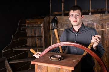 Young Man Steering Wooden Antique Ship © kolotype