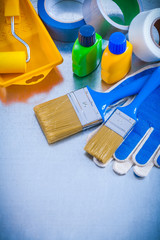 Duct tapes safety gloves and paint tools on metallic background 