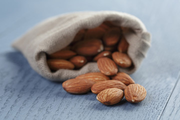 almonds in sack bag on blue wood table