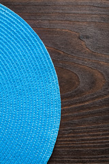 vertical view wickered round mat on vintage wooden board