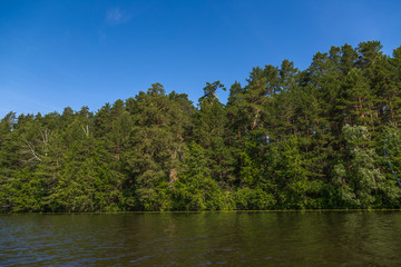 Fototapeta na wymiar Протока на реке на фоне голубого неба. Водный пейзаж