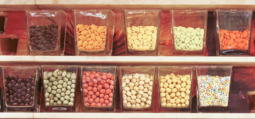 Gläser mit Süßigkeiten und Bonbons auf einem Regal