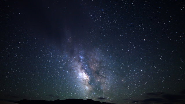  Astrophotography time lapse footage with zoom out motion of Milky Way galaxy over desert sand dunes in Death Valley National Park, California