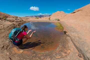 Backpacker splashing water,