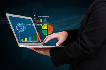 businessman holding a laptop showing business graph on virtual s