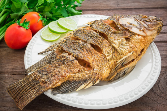 Fried fish on plate with vegetables