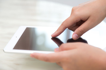 Woman hand touch white tablet with blank empty screen