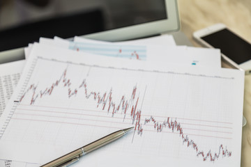 Financial charts on the table with laptop