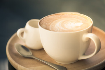 Hot latte art coffee on table ( Filtered image processed vintage