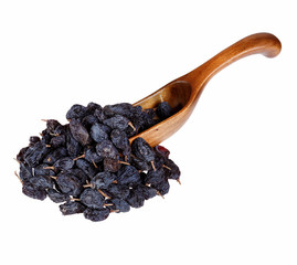 Black raisins in the wooden spoon, isolated on white background.