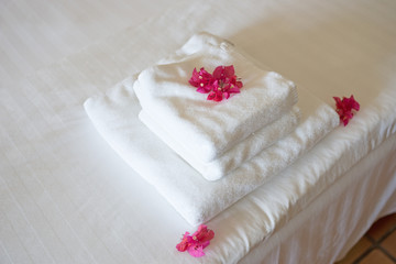 Frische Handtücher im Hotel, geschmückt mit Blüten