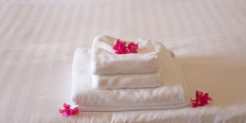 Frische Handtücher im Hotel, geschmückt mit Blüten