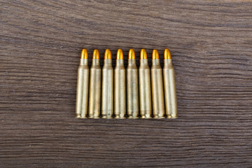 Rifle bullets on wood table.