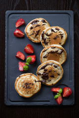 Pancakes with chocolate and fresh strawberries, above view