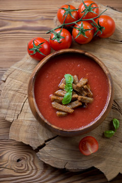 Tomato soup gazpacho over wooden background, view from above