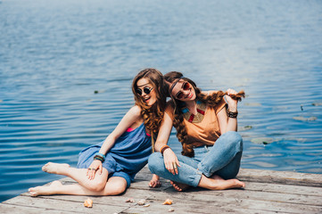 two beautiful girl friends on the dock
