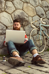 Trendy hipster young man with laptop