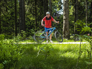 man enjoys ridimg mountain bike in the forest