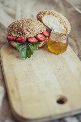 Breakfast of berries with a bun and honey on a wooden Board