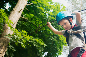 Five year boy on rope-way in forest