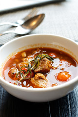 Pork stew in white bowl on wooden table