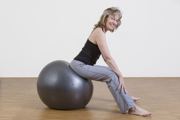 Frau macht Gymnastik mit Pilates Ball