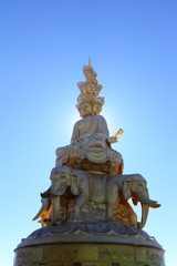 Fototapeta na wymiar Samantabhadra statue with sun behind
