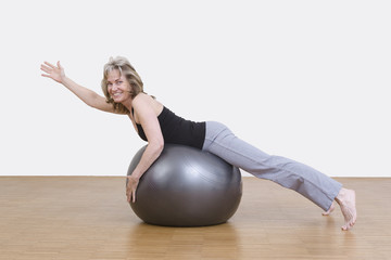 Frau macht Gymnastik mit Pilates Ball
