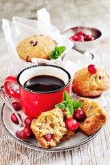 Oatmeal muffins with fresh cranberries, and coffee in enamel mug. Selective focus