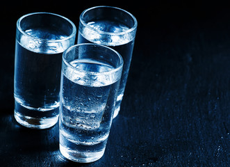 cold Russian vodka on a dark background in the neon light, selec