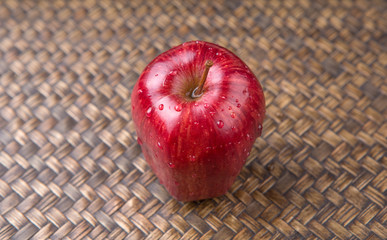 Red apples over wicker background