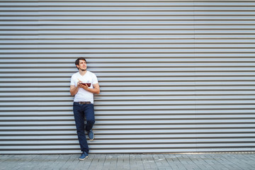 A young man with a notebook on the metal background