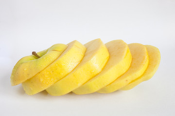 Fototapeta na wymiar Single yellow apple cut into diagonal slices