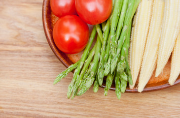 tomatoes, asparagus and baby corn on a plate