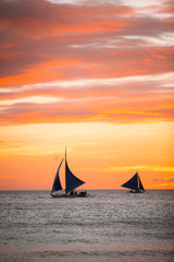 Sailing boats with a beautiful sunset at the sea