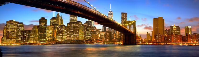 Manhattan skyline panorama with Brooklyn Bridge at dusk, New York