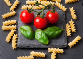 Pasta ingredients concept on black slate background viewed from the top