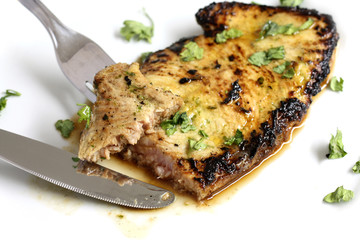 served delicious piece of tuna steak with greenery and dinnerware
