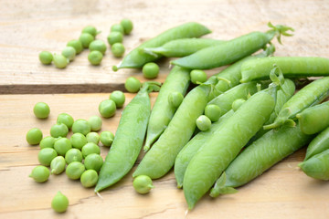 Fresh green peas on wooden table