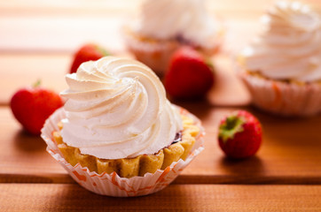 cake with white cream and fresh strawberries on table