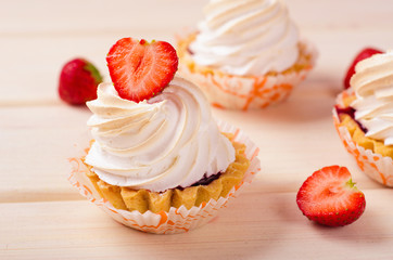 cake with white cream and fresh strawberries on table
