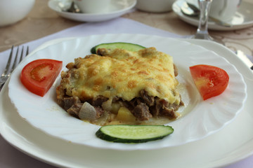 Baked meat with potatoes and cheese.