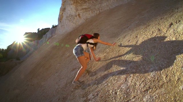Woman hiking and climbing . Strong determined tourist woman is climbing the rock in sunny Grand Canyon. Slow motion filmed at 250 fps.