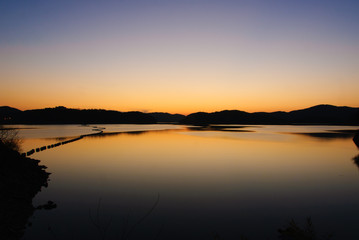 Fototapeta na wymiar blue and orange gradation of sunset on the JINYANG lake
